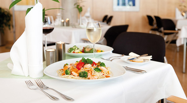 Laid table with a pasta dish and a glass of wine