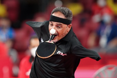  Foto von Markus Brandt (dpa) zeigt frontal Tischtennisspieler ohne Arme, Schläger im Mund, Augen auf den Ball gerichtet, der angeflogen kommt.