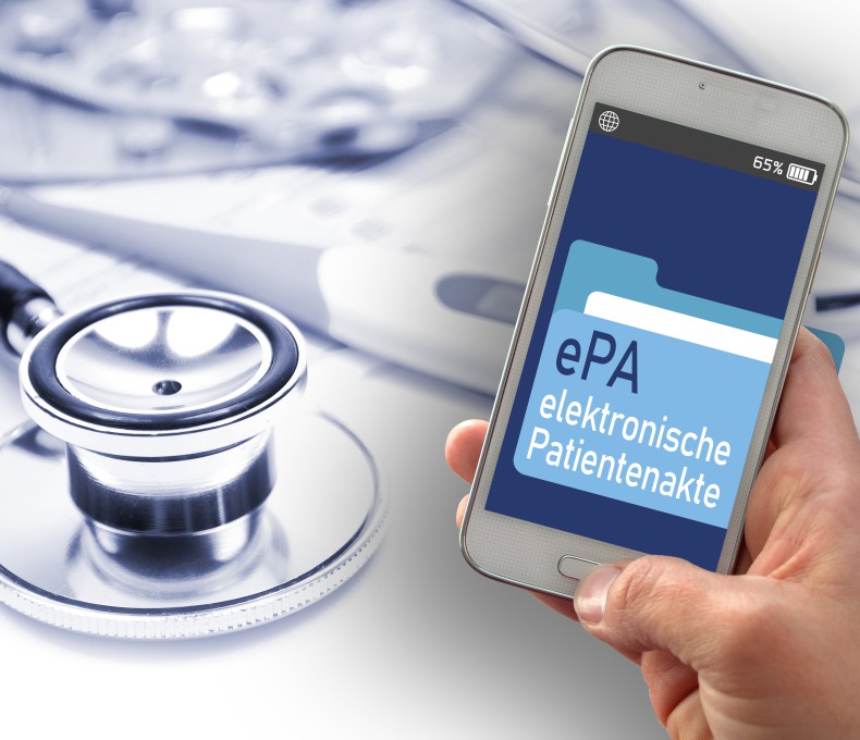 Das Bild zeigt eine Hand, die ein Smartphone hält. Auf dem Bildschirm des Smartphones ist eine Anwendung mit der Aufschrift „ePA – elektronische Patientenakte“ zu sehen. Im Hintergrund liegen medizinische Utensilien, wie ein Stethoskop und Tablettenblister. Das Bild zeigt eine Hand, die ein Smartphone hält. Auf dem Bildschirm des Smartphones ist eine Anwendung mit der Aufschrift „ePA – elektronische Patientenakte“ zu sehen. Im Hintergrund liegen medizinische Utensilien, wie ein Stethoskop und Tablettenblister.