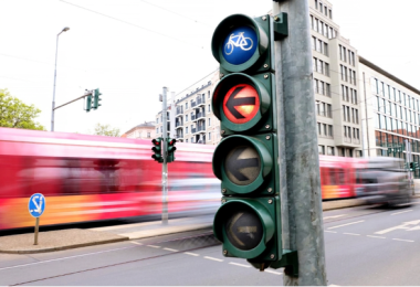 Ampel mit Fahrradsymbol zeigt Rot, Straßenbahn fährt im Hintergrund vorbei. (Bild: DVR/Daniela Stanek)